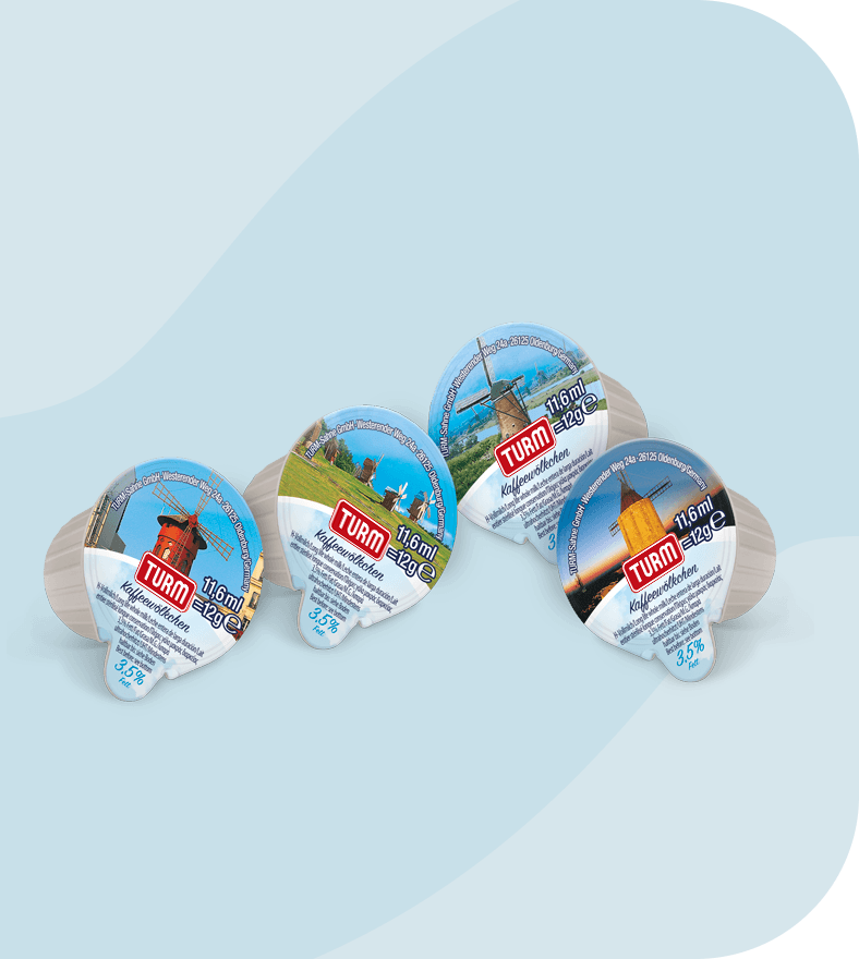 Vier TURM KaffeeWoelkchen Portionspackungen nebeneinander vor blauem Hintergrund